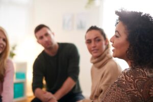 a therapist talks with a group about the benefits of group therapy